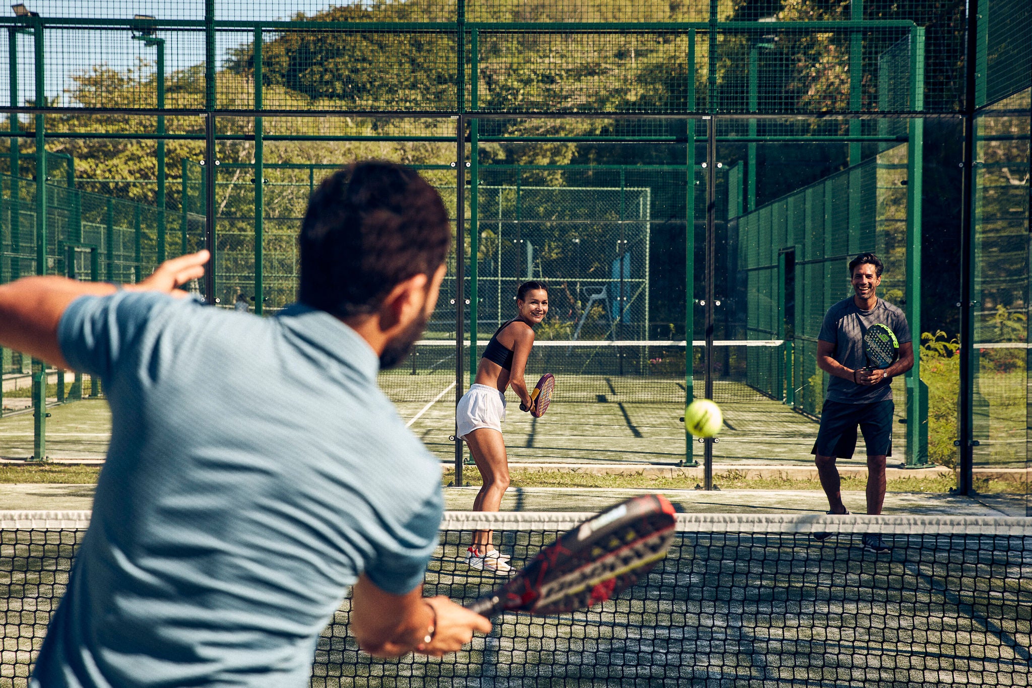A couple learning to play Padel with a coach at Club Med