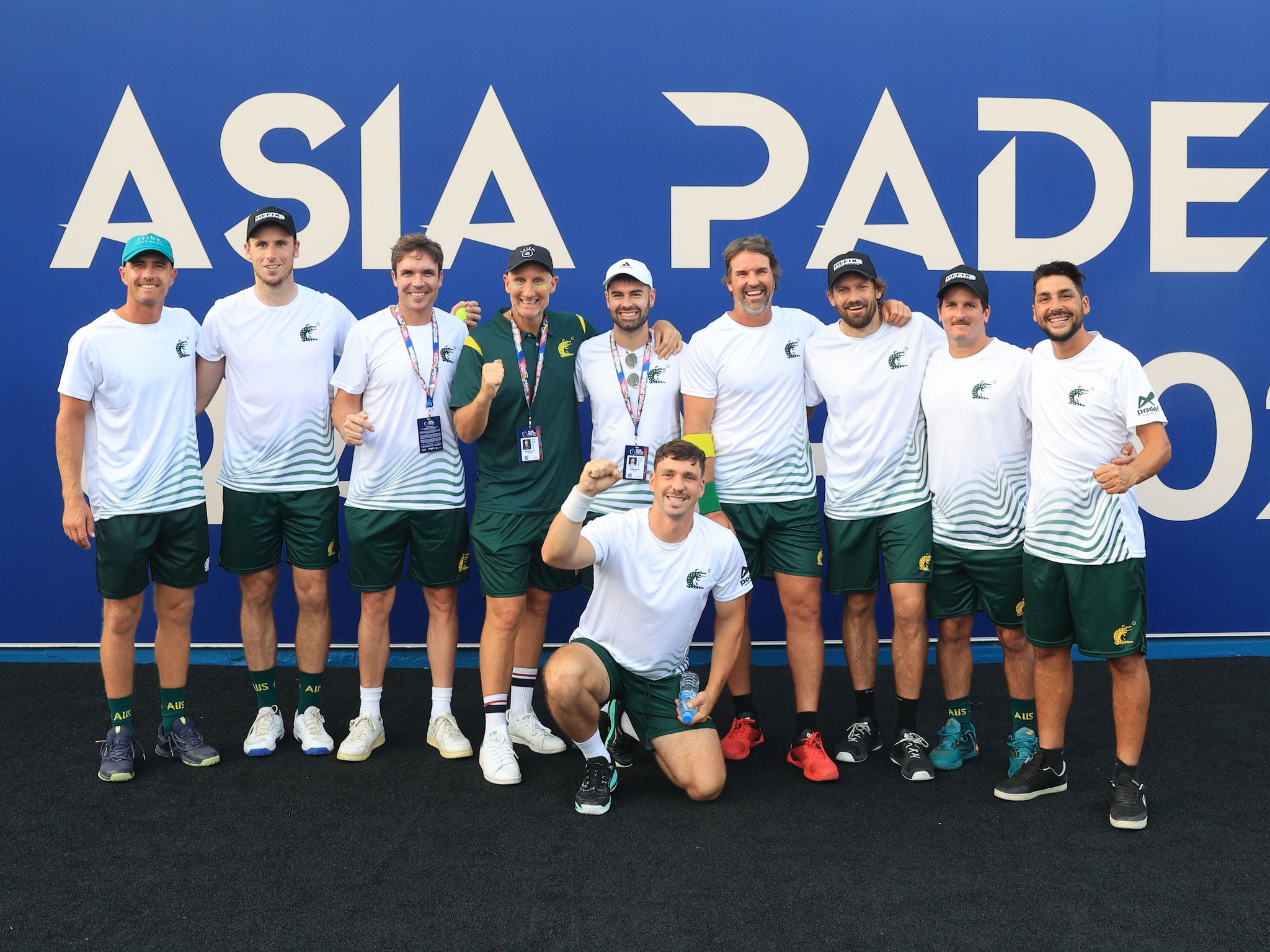 A group of Men Padel players wearing white, green and gold.
