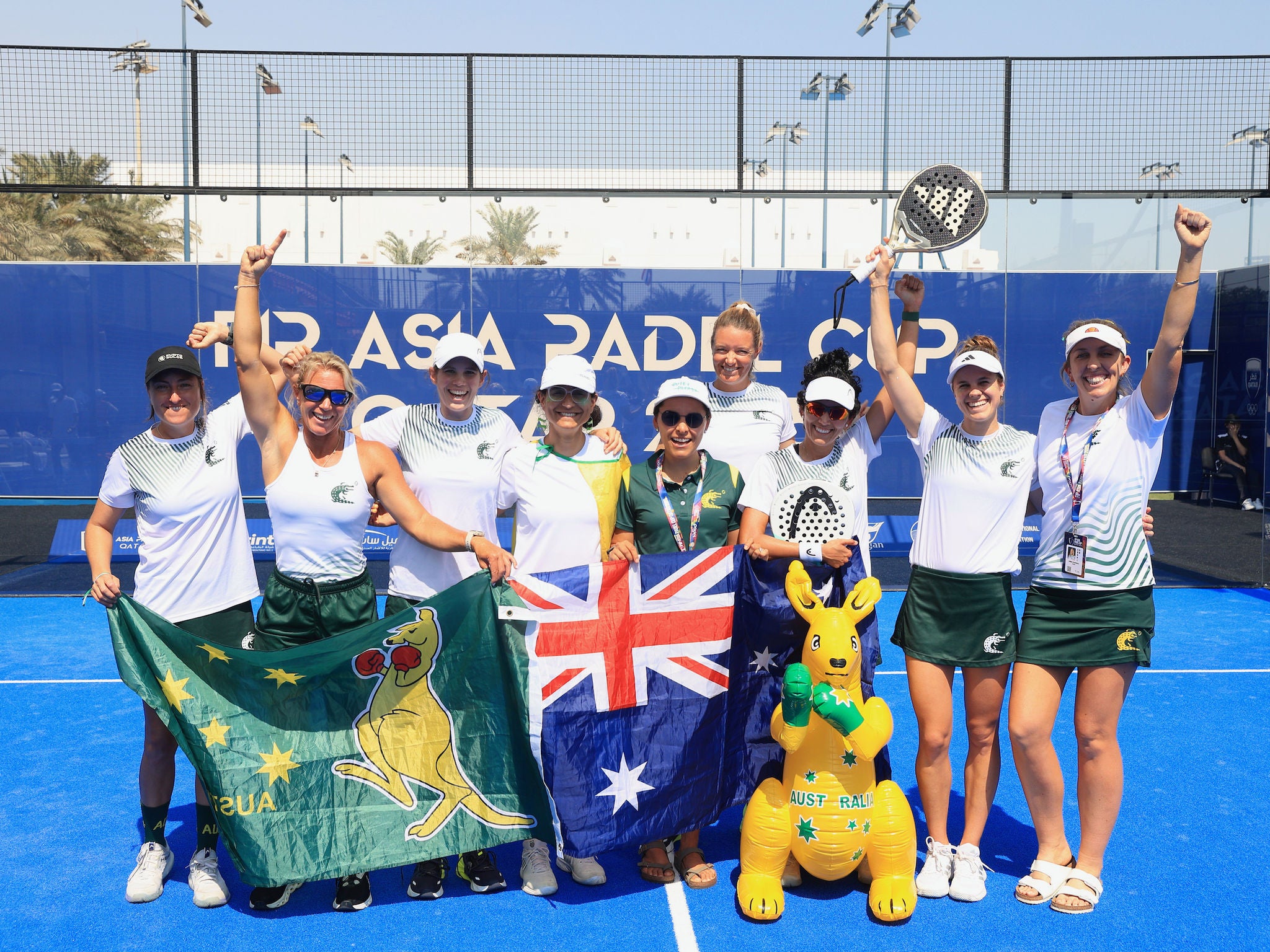 A group of women Padel players dressed in white, green and gold with the Australia Flag and a Kangaroo